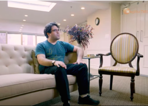 Patient sits on couch as Sunrise Psychiatry in Overland Park, Kansas. Hear testimonials about Transcranial Magnetic Stimulation.